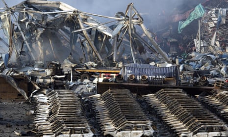 Charred remains of a warehouse and new cars are left burned after explosions at a warehouse.