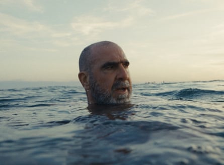 A shaven-haired man with a beard is seen in the sea.