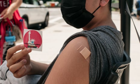 A 14-year-old vaccinated against Covid-19 holds up a sticker at a pop-up vaccination site in Queens, in New York City. 