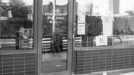A Justice for Cornelius Taylor sign hangs on the storefront of Remerge, a non-profit