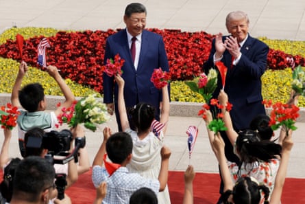 Two men in suits smile while children cheer in front of them