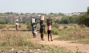 Bulawayo residents carry water home from a borehole in the township of Luveve.