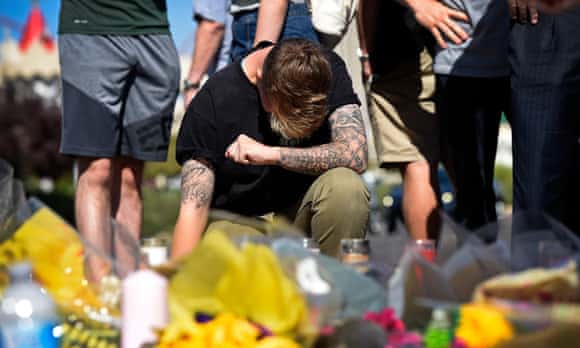 Bry Thompson, 21, of Las Vegas kneels at a makeshift memorial.