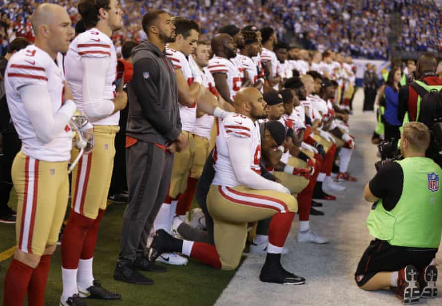 Members of the San Francisco 49ers kneel during the playing of the national anthem.