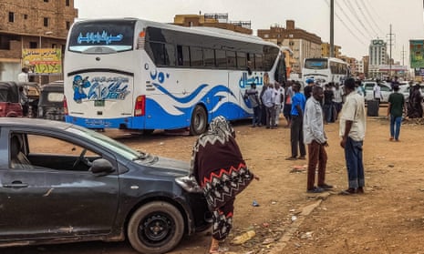 People prepare to board a bus departing from Khartoum in the Sudanese capital's south in April amid fighting  between the army and paramilitaries
