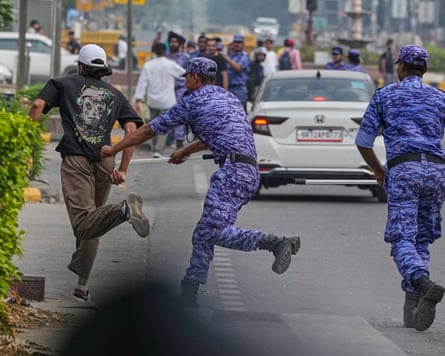 Security personnel chase a protester.