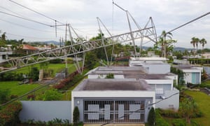 A power line tower downed by the passing of Hurricane Maria lies on top of a house in San Juan, Puerto Rico