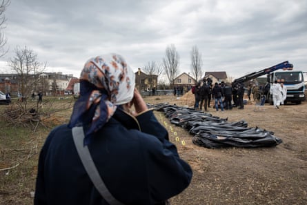Natalia Lukyanenko, 63, watches authorities excavate a mass grave in the grounds of the Church of St Andrew and Pyervozvannoho in Bucha, April 2022