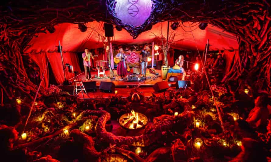 Band performs connected a stage, astatine night, successful beforehand of an audience, illuminated by tiny lanterns, astatine the Medicine festival successful Berkshire, UK, August 2021.