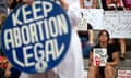 Out-of-focus blue 'Keep abortion legal' sign with a person holds a sign in the back