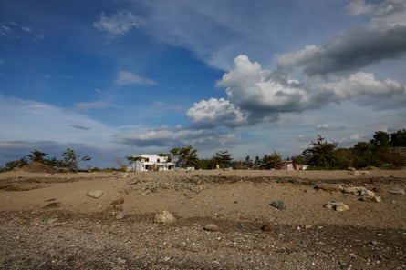 A rocky shore with a couple of run-down buildings