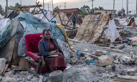 Pastor Regina Ndinda, 53, takes comfort from her Bible after her church and home of 25 years was demolished