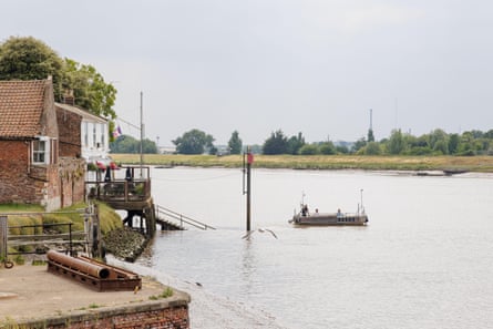 The King’s Lynn foot ferry on its way to West Lynn, across the Ouse. Landing stage and river, small boat.