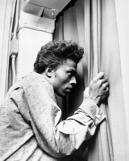 Musician Little Richard peers out of a curtain circa 1957.