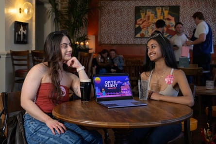 Two woman sit in a pub in Fulham with a laptop open on the table in front of them.