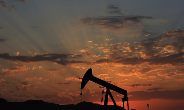 An oil pump at sunset in the desert oilfields of Sakhir, Bahrain
