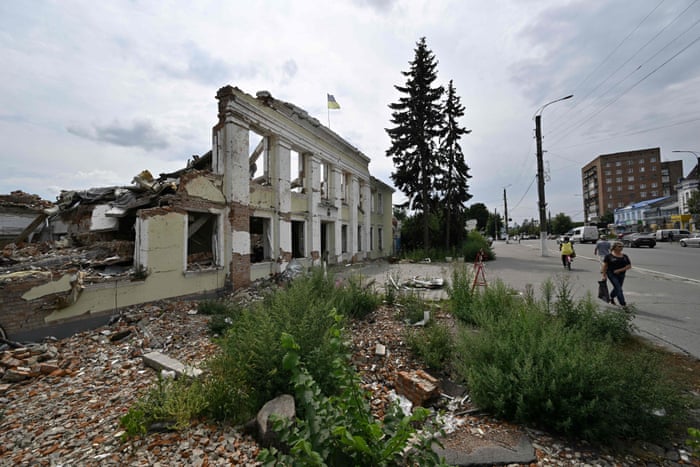 Pedestrians walk in front of the city hall building in the city of Okhtyrka, Sumy.