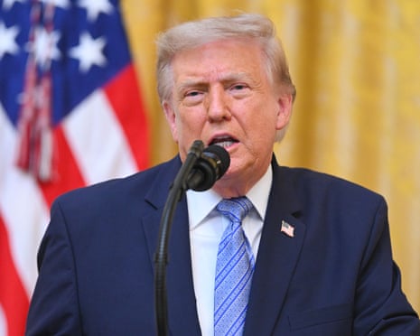 Trump in front of yellow curtain, speaking.