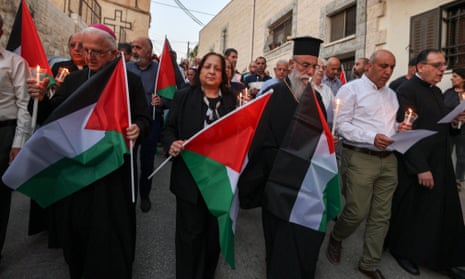 Palestinian Christians wave national flags during a demonstration in solidarity with the people of Gaza in the village of Jifna, north of Ramallah in the occupied West Bank on Monday.