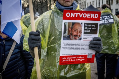 A pro-Israeli protester holds up a poster featuring the image of one of the people believed to be held captive in Gaza.