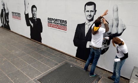 Reporters Without Borders activists paste up posters of presidents Putin, Xi and al-Assad. Press freedom deteriorated in 2015, the group says.