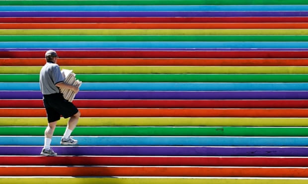 A city hall employee walks up a flight of stairs painted in rainbow colours in Vancouver