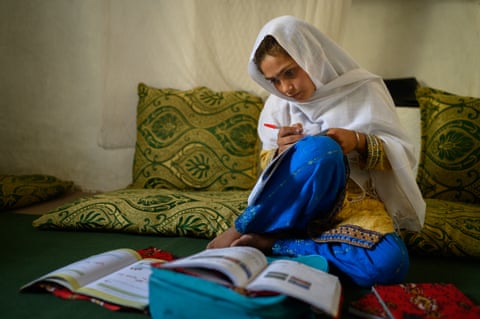 A girl sitting on the floor with her schoolbooks