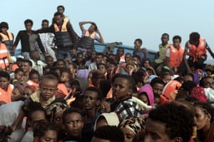 Refugees and migrants wait to be rescued