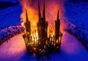 Spectators watch the burning of a structure constructed with twigs and debris in the form of a Gothic-style building by Russian artist Nikolay Polissky during Shrovetide.