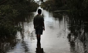 A man walks through a flooded street in Naples, Florida.