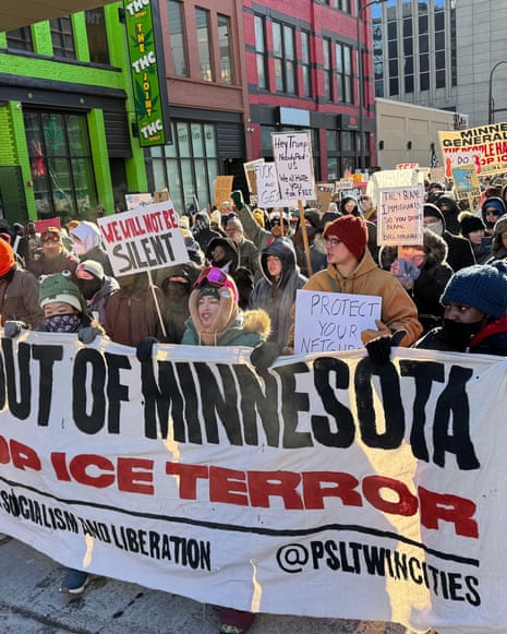 a group of people hold a banner saying 'ICE out of minnesota' at a protest as other people follow behind
