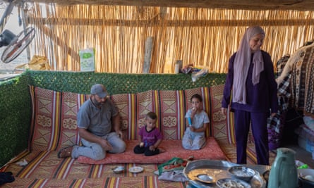 Mahmud, his son Walid, 3, his daughter Joan, 5, wait inside what now serves as their now home while Beyan, his older daughter, helps prepare breakfast in Jawaya of the south Hebron hills.
