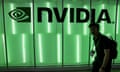 person walks past a green wall with NVIDIA logo