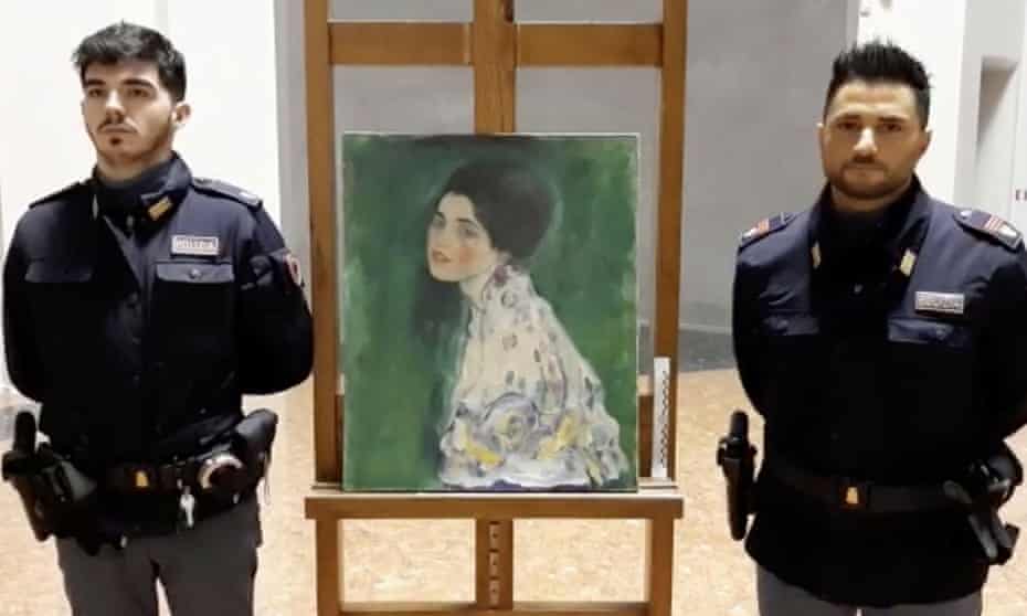 Italian police stand next to what they say could be the Portrait of a Lady painting, by the Austrian artist Gustav Klimt, which was stolen in 1997.