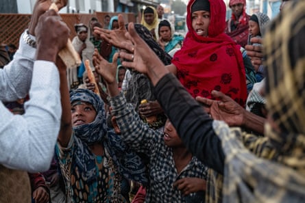 Families reach out their hands for bread in the centre of Borama city, Somaliland