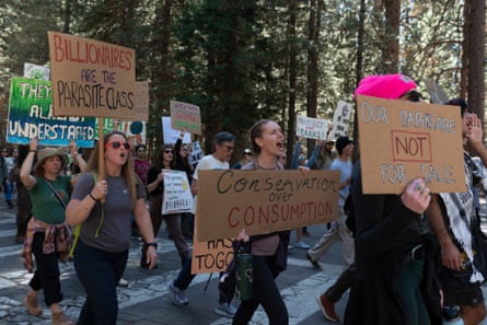 people hold signs against layoffs in a national park