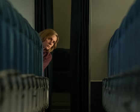 person sitting in row of chairs looks back