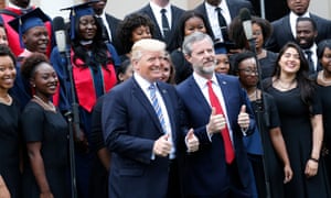 Donald Trump poses with Jerry Falwell Jr in front of a choir during commencement ceremonies in Lynchburg, Virginia, on 13 May 2017. 