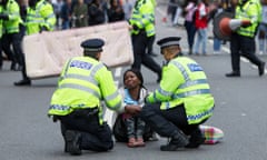Police with a protester demanding justice after the death of Rashan Charles, London, July 2017