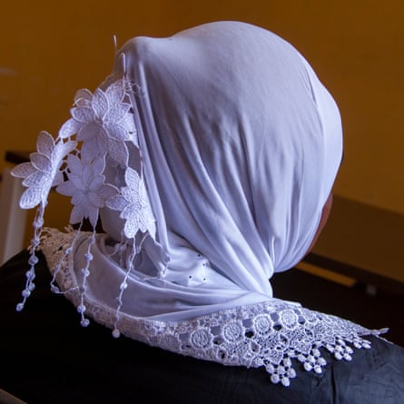 A woman wearing a veil looks away from the camera