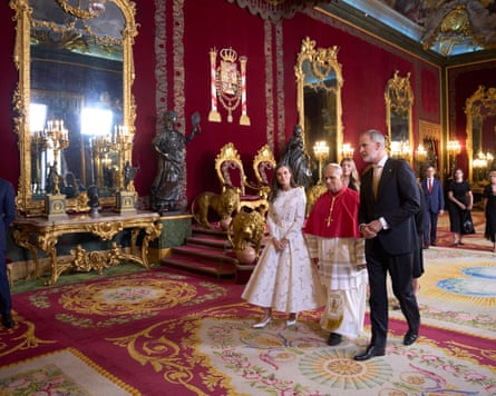 Queen Letizia, Pope Leo and King Felipe walk through an ornate and gilded room in the palace