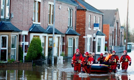 Rescue workers helping residents to safety in Carlisle after heavy rain from Storm Desmond in 2016.