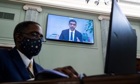 Sundar Pichai, CEO of Google, appears on a monitor behind a stenographer as he testifies remotely during the Senate committee hearing in October 2020.