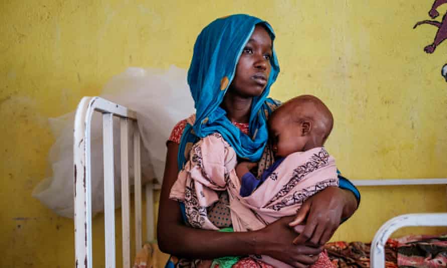 Uma mulher segurando uma criança desnutrida em Kelafo, leste da Etiópia, no mês passado