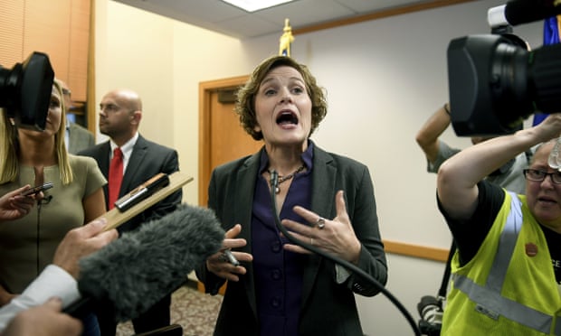 Minneapolis mayor Betsy Hodges tries to talk to the media as she is shouted at by protesters during her press conference on Friday night over the resignation of police chief Janeé Harteau.