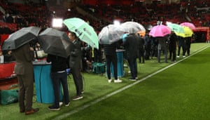 Television broadcasters hide under their brollies.