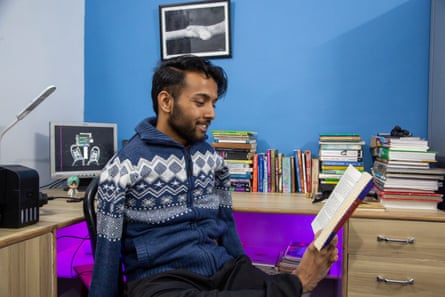 Bikram Bhattarai reads a book held between his toes