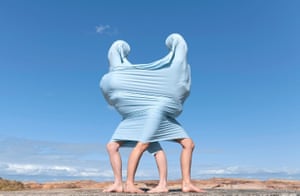 Two people push in opposite directions inside stretchy fabric