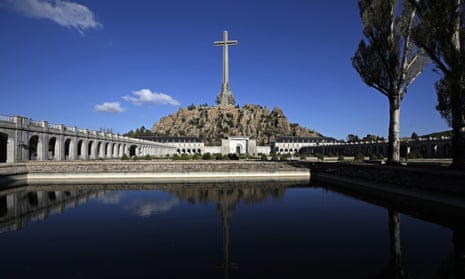 the valley of the fallen mausoleum is a large obelisk with cross overlooking a pond