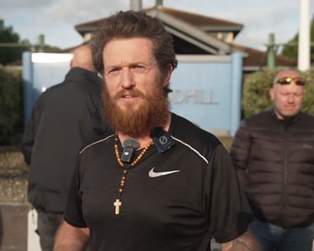 A bearded Tommy Robinson, wearing a cross.